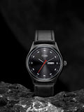 TOMI T-030 Men's Watch – All-black watch with a dark dial, red second hand, and black leather strap on a textured stone surface.