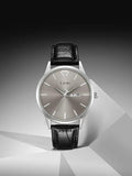 TOMI T-045 Quartz Wrist Watch For Men - Silver case watch with a metallic silver dial and black strap on a geometric background.