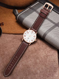 TOMI T-035 Men Wrist Watch Quartz Date - White dial watch with a brown leather strap laid flat on a textured brown surface.