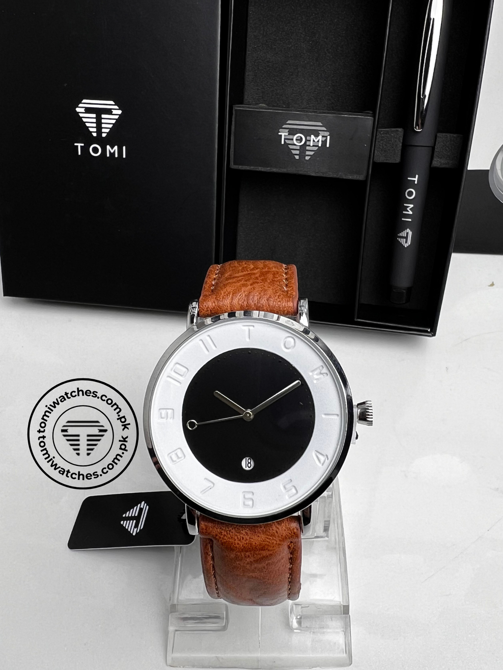 White dial TOMI T-085 men's watch with tan leather strap and silver case on display