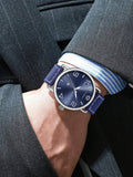 TOMI T-035 Men Wrist Watch Quartz Date - Blue dial watch with a blue leather strap worn on a wrist with a suit and striped cuff.