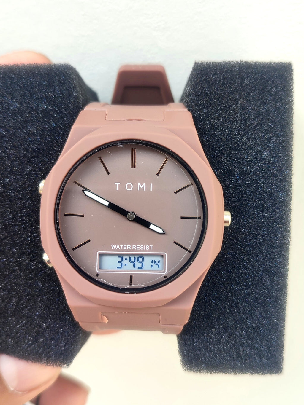 Detailed view of the Tomi T-238 taupe watch secured on a black foam insert
