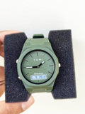 Close-up view of the Tomi T-238 olive green watch on a black foam display holder