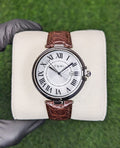 TOMI T-075 silver dial business watch with a brown leather strap displayed on a white cushion.