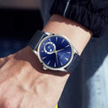 TOMI T-024 blue dial leather strap watch worn on wrist outdoors