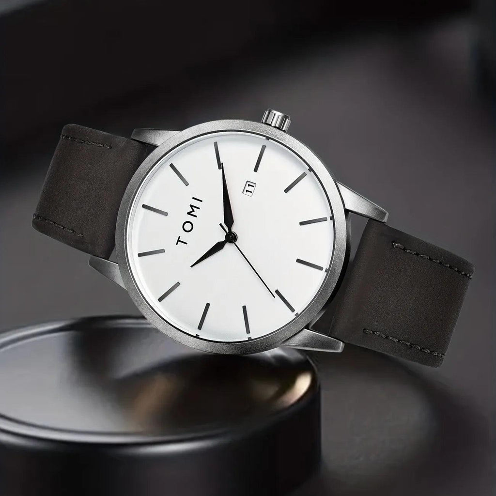 TOMI T-071 Men's Watch Date Quartz - White dial watch with silver bezel and dark grey leather strap standing on a black circular stand.